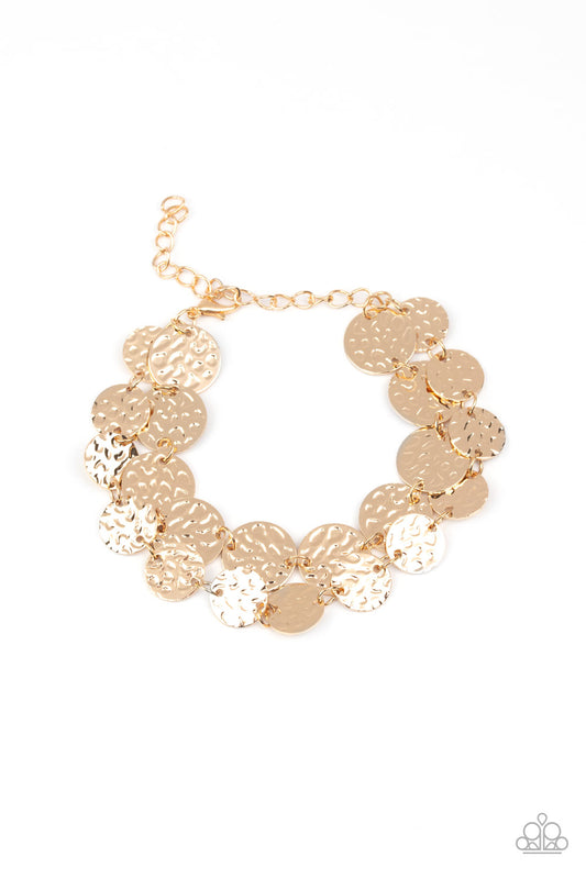 Two rows of hammered gold discs wrap around the wrist, creating an edgy shimmer.